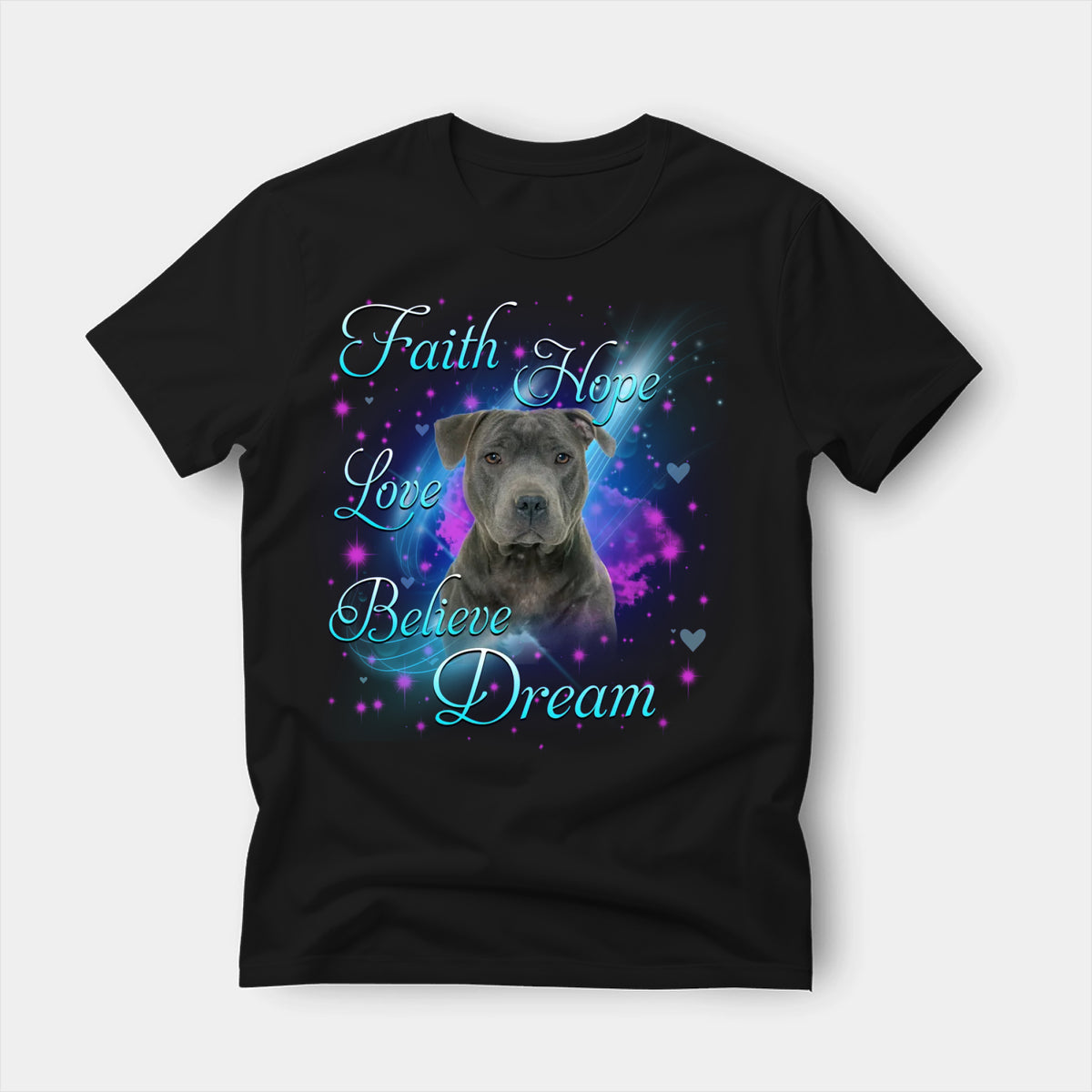 Black t-shirt printed with a Staffordshire Bull Terrier with the words Faith, Hope, Love, Believe and Dream in glowing script on a sparkling blue background
